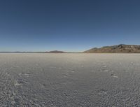 the sky is clear and clear on this desert area with small footprints on the ground