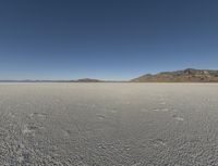 the sky is clear and clear on this desert area with small footprints on the ground