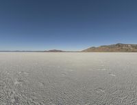 the sky is clear and clear on this desert area with small footprints on the ground