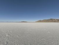 the sky is clear and clear on this desert area with small footprints on the ground