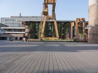 a clock tower sitting in the middle of a wooden courtyard on a sunny day in the city
