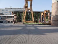 a clock tower sitting in the middle of a wooden courtyard on a sunny day in the city