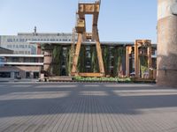 a clock tower sitting in the middle of a wooden courtyard on a sunny day in the city