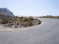 a motorcycle rider in the middle of an empty mountain road next to a sign indicating that the road is closed