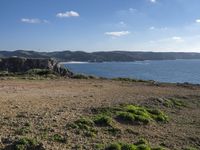 a dirt path leading to the shore line on the beach in the foreground is the coast