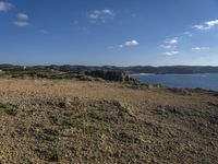 a dirt path leading to the shore line on the beach in the foreground is the coast