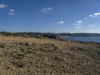 a dirt path leading to the shore line on the beach in the foreground is the coast