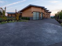 circular driveway with grey paving in front of a home that is designed around two large concrete slabs