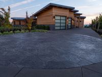 circular driveway with grey paving in front of a home that is designed around two large concrete slabs