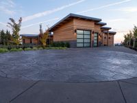 circular driveway with grey paving in front of a home that is designed around two large concrete slabs