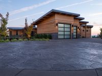 circular driveway with grey paving in front of a home that is designed around two large concrete slabs