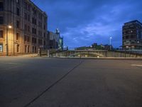 the side walk of an old city block at night with a stop sign and street lights