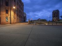 the side walk of an old city block at night with a stop sign and street lights