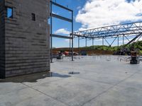 people standing around near the unfinished building under construction on a partly sunny day at the intersection of a road