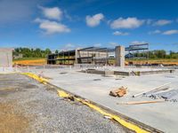 a view of a construction area and buildings with a cloudy blue sky in the background