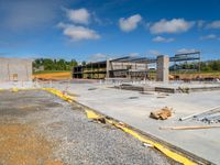 a view of a construction area and buildings with a cloudy blue sky in the background