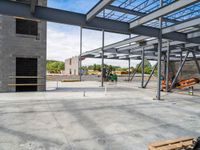 an empty construction yard with a concrete floor and metal structures for workers to construct in