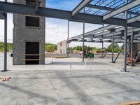 an empty construction yard with a concrete floor and metal structures for workers to construct in