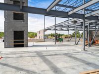 an empty construction yard with a concrete floor and metal structures for workers to construct in