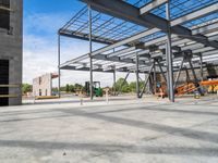 an empty construction yard with a concrete floor and metal structures for workers to construct in