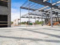 an empty construction yard with a concrete floor and metal structures for workers to construct in