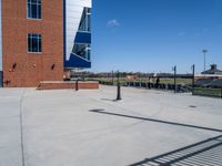 the parking lot of a stadium with a gate on it and a football field in the background