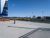 the parking lot of a stadium with a gate on it and a football field in the background