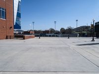 the parking lot of a stadium with a gate on it and a football field in the background