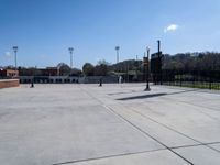 the parking lot of a stadium with a gate on it and a football field in the background