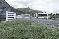 there is a road that runs through a rocky valley with a fenced in area