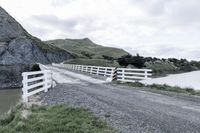 there is a road that runs through a rocky valley with a fenced in area