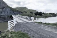 there is a road that runs through a rocky valley with a fenced in area