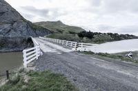 there is a road that runs through a rocky valley with a fenced in area