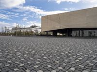 an empty building with a large sidewalk and cobbles on it's side of the street