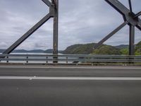 a view of the bridge and the water from a window in the car, which appears to be an empty street