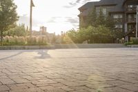 a man riding a skateboard on top of a brick sidewalk of some sort at sunset