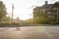 a man riding a skateboard on top of a brick sidewalk of some sort at sunset