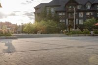 a man riding a skateboard on top of a brick sidewalk of some sort at sunset