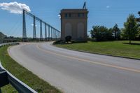 the roadway has the road going up to the bridge and has some large poles over it