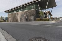 a building with many windows and some grass on the sidewalk in front of it is empty