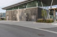 a building with many windows and some grass on the sidewalk in front of it is empty