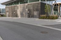 a building with many windows and some grass on the sidewalk in front of it is empty