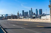 empty highway with city skyline in background and no cars on it and signs on it