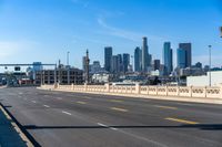 empty highway with city skyline in background and no cars on it and signs on it