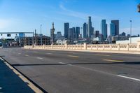 empty highway with city skyline in background and no cars on it and signs on it