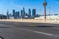 empty highway with city skyline in background and no cars on it and signs on it