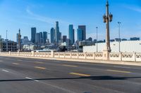 empty highway with city skyline in background and no cars on it and signs on it