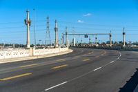 a view of an empty highway and the sky is blue with a few clouds in the sky