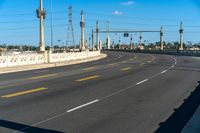 a view of an empty highway and the sky is blue with a few clouds in the sky