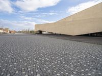 an empty courtyard is shown in this picture with a building that has many windows and some buildings